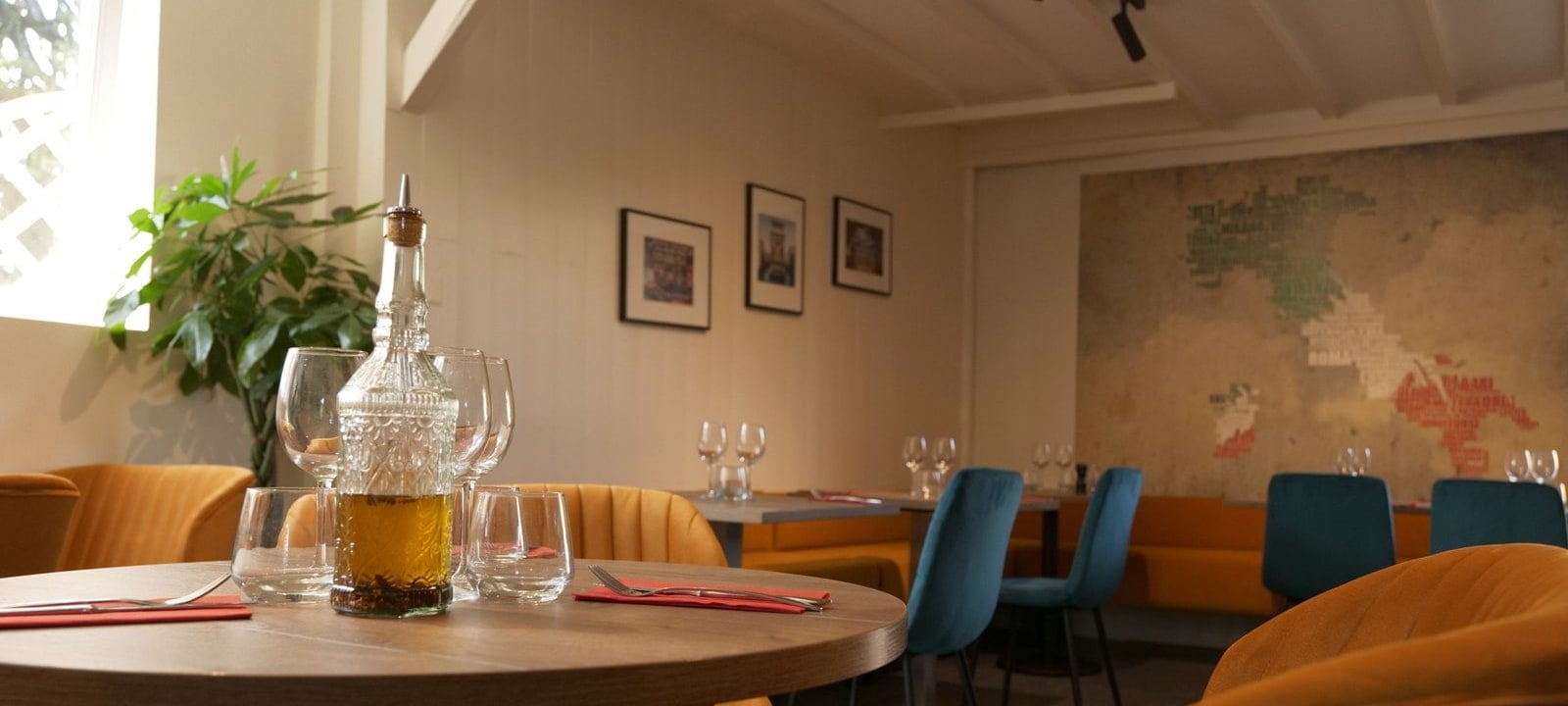Salle du restaurant O'Divino Melesse, tables dressées et carte d'Italie au mur